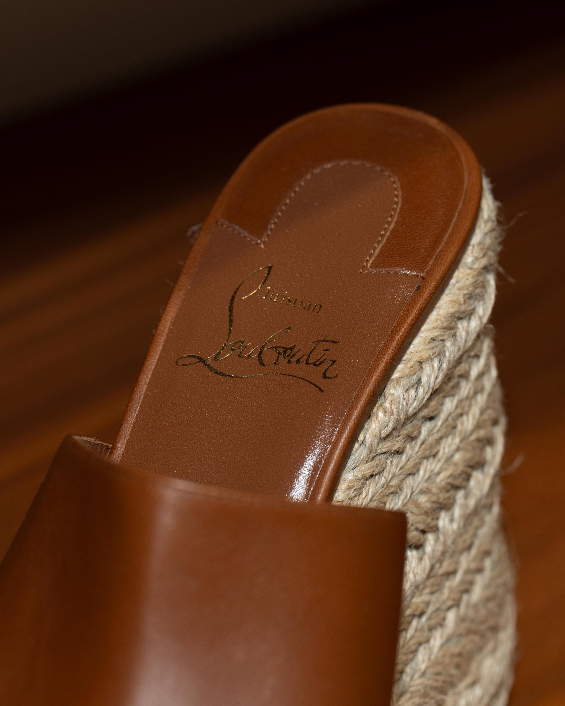 Brown sandal with jute sole on a wooden floor